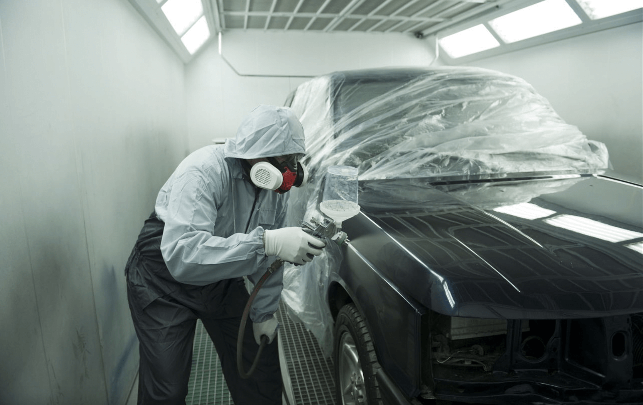 Peintre qui applique une peinture voiture au pistolet